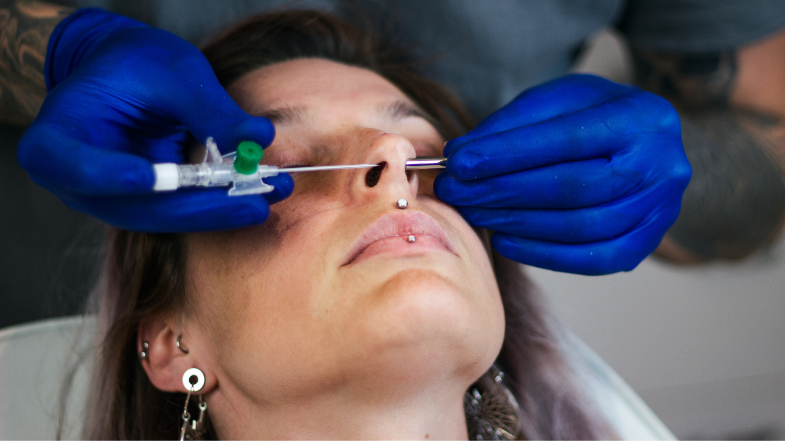 Professional piercing procedure illustrating the invasive nature and risk of infection from body modification.