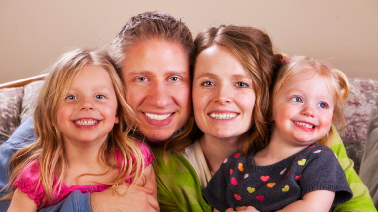 A happy family smiling together during a visit at Professional Dental in Utah, highlighting healthy smiles and family dental care.